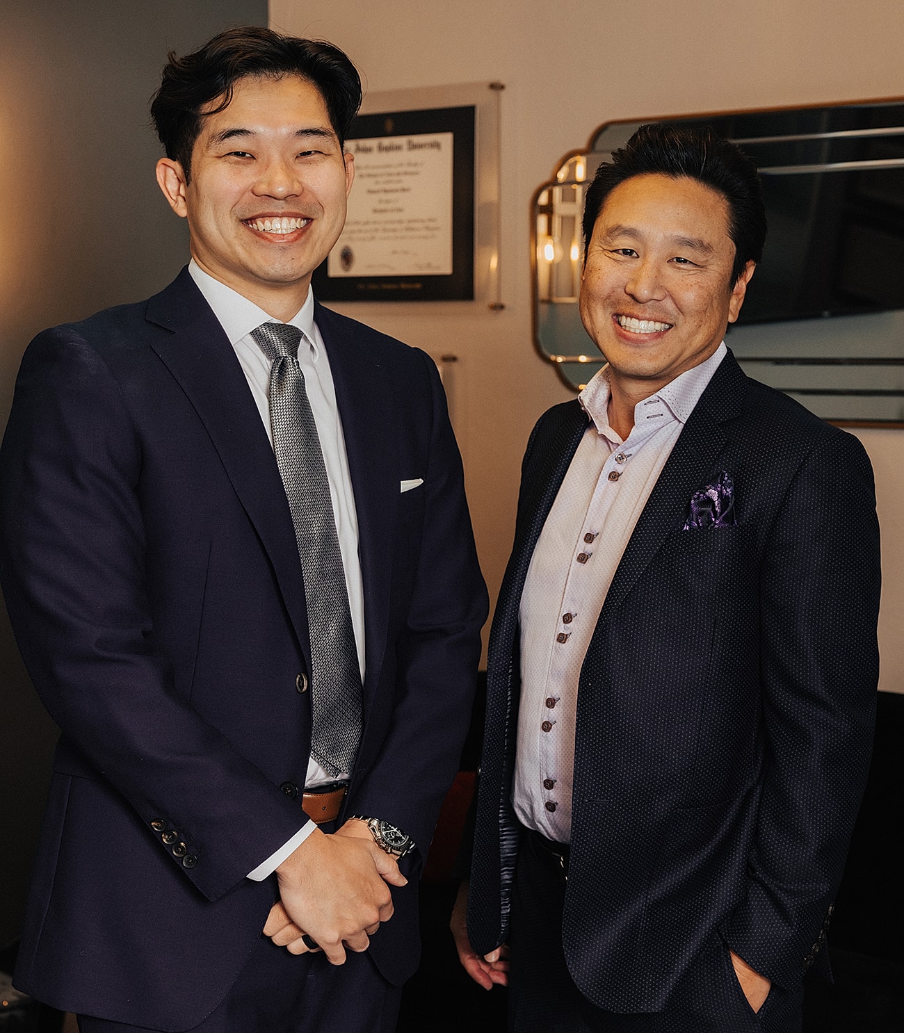 Two men smiling in business attire.