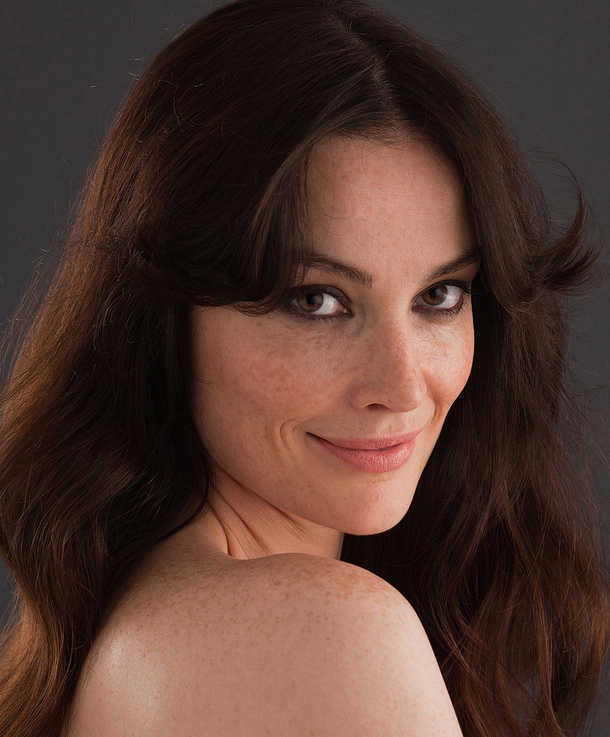 Smiling woman with long, wavy hair.