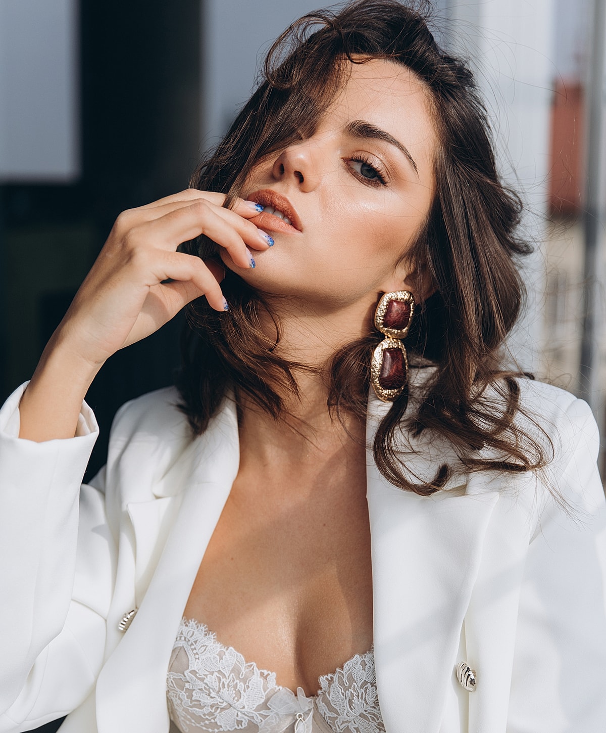 Woman in stylish outfit with elegant earrings.