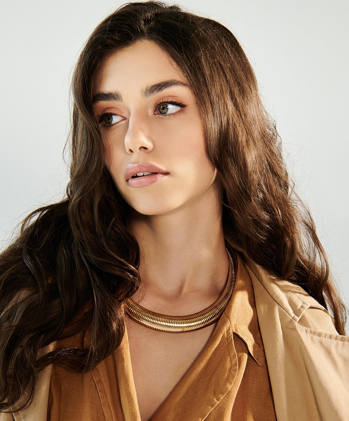 Model with long hair wearing stylish necklace.