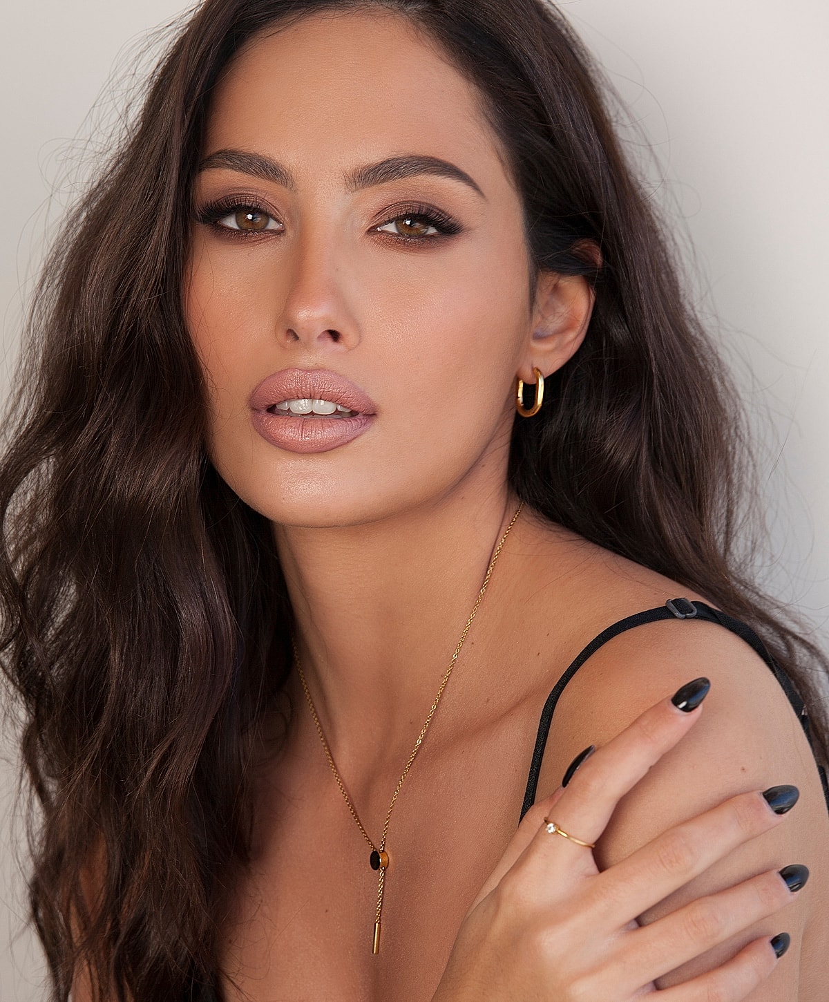 Model with wavy hair and elegant jewelry.