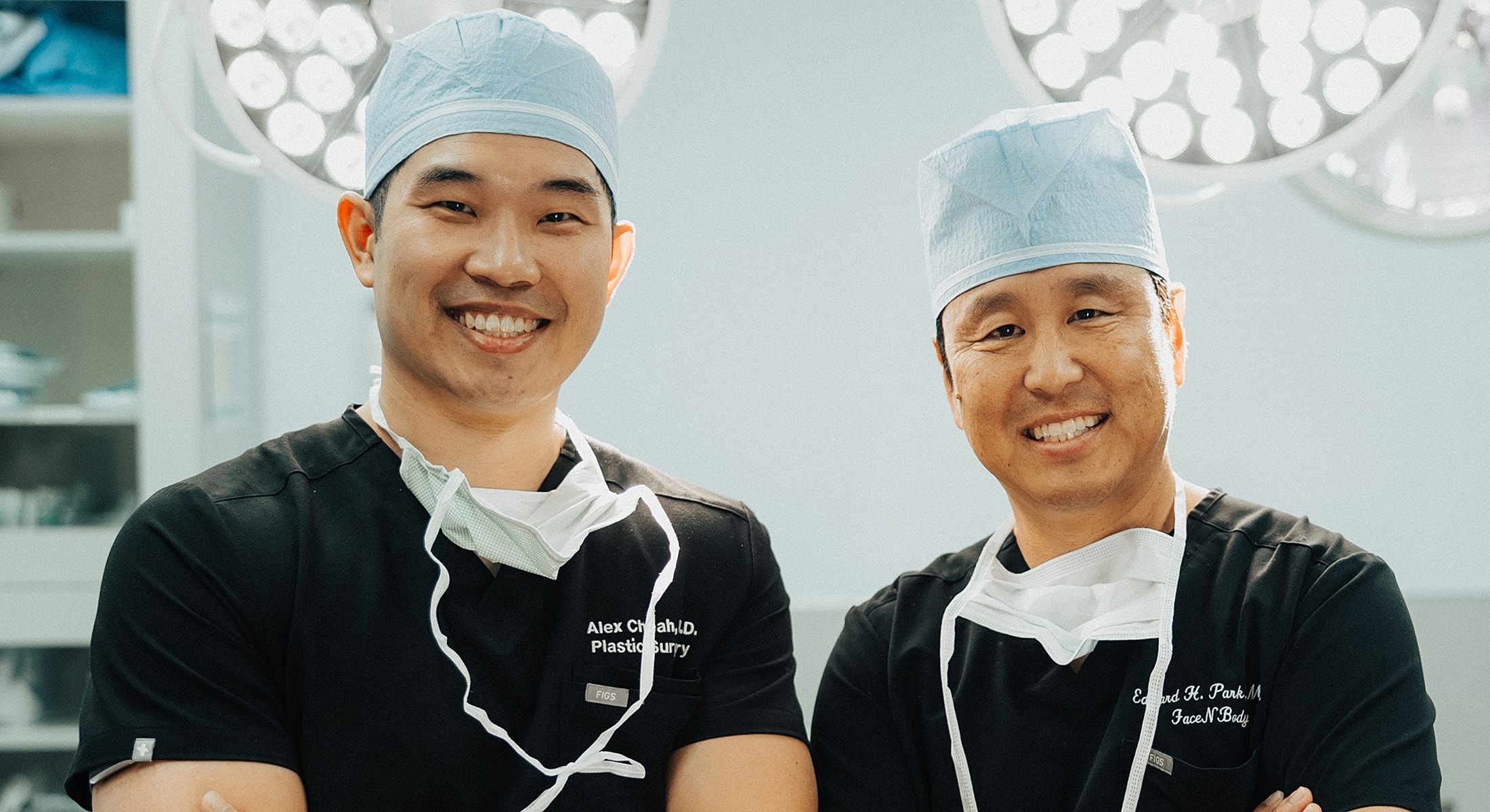 Two surgeons smiling in a hospital setting.