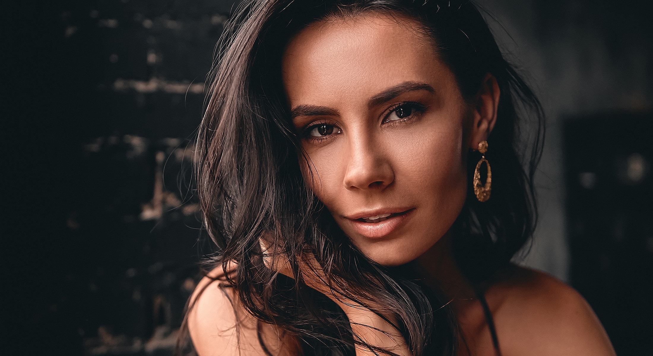 Woman with long hair and statement earrings.